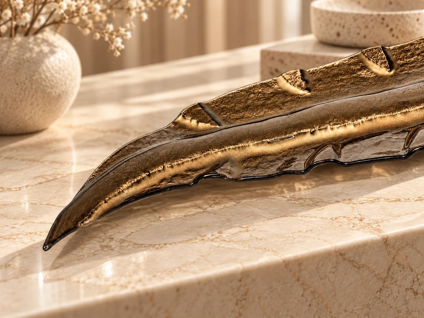 Detalhe da textura de uma peça de vidro bronze sobre travertino sob luz dourada